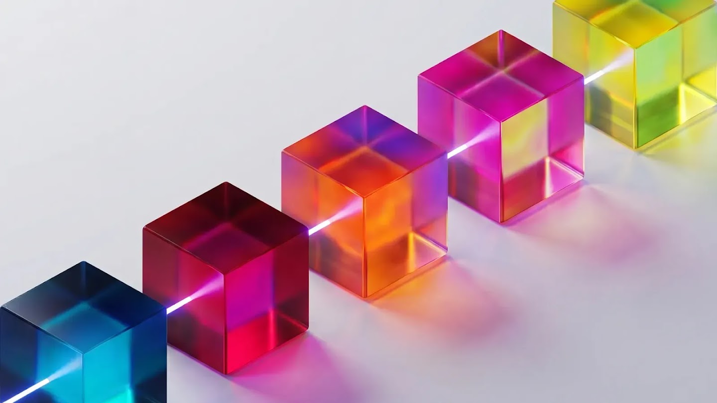A row of five translucent, colorful glass cubes arranged diagonally on a white surface, with a bright beam of white light passing directly through them.
